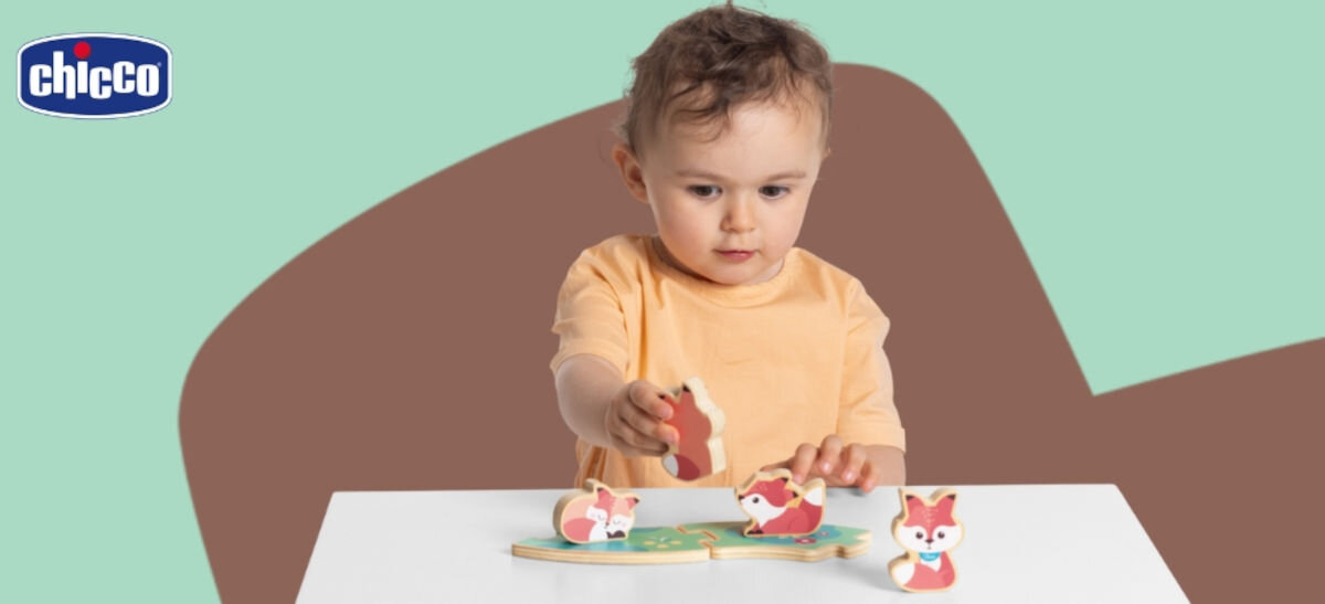 Zabawka CHICCO My Wood Friends Drewniana rodzinka 2 Liski Zestaw Tata 00012208500000,
zielono-brązowe tło, zabawki na białym stoliku, dziecko