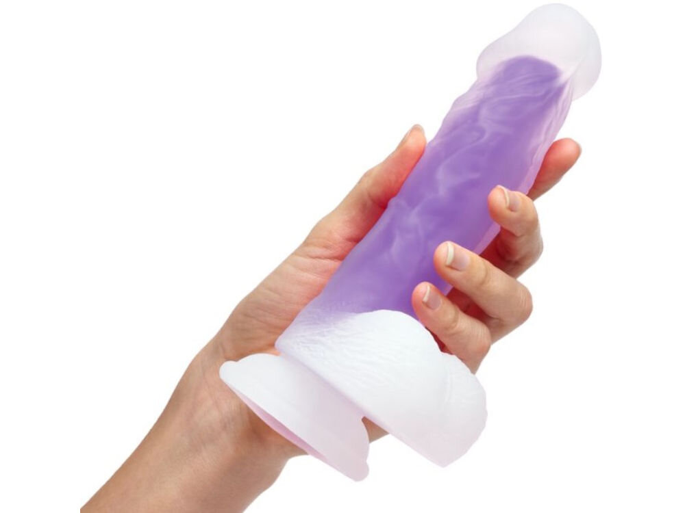 Naturalistyczne dildo SO DIVINE Glorious Fioletowy białe tło osoba trzyma biało fioletowe dildo w dłoni przyssawka na dole urządzenia Chwila przyjemności
