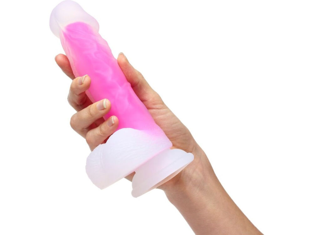 Naturalistyczne dildo SO DIVINE Glorious Różowy białe tło osoba trzyma biało różowe dildo w dłoni przyssawka na dole urządzenia Chwila przyjemności