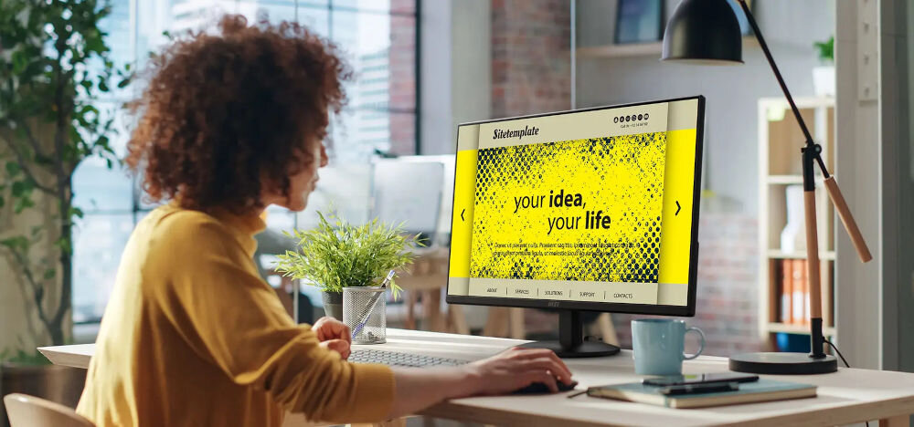 Monitor MSI Pro MP242L 23.8 cala 1920x1080px IPS 100Hz 1 ms [MPRT] prezentacja monitora kobieta siedząca przy nim przy biurku cienkie ramki płynny obraz EyesErgo MSI Power Link wsparcie wygody komfort efektywność