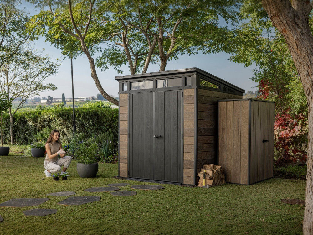 Domek narzędziowy KETER Penthouse Signature Collection 259814, pogoda, deszcz, ochrona, UV, kobieta plewi rośliny, w tle domek keter w ogrodzie