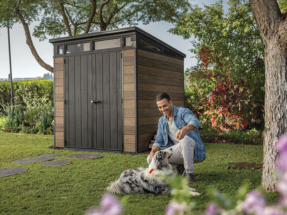 Domek narzędziowy KETER Penthouse Signature Collection 259814, design, styl, harmonia, wygląd, mężczyzna bawi się z psem, w tle domek keter w ogrodzie