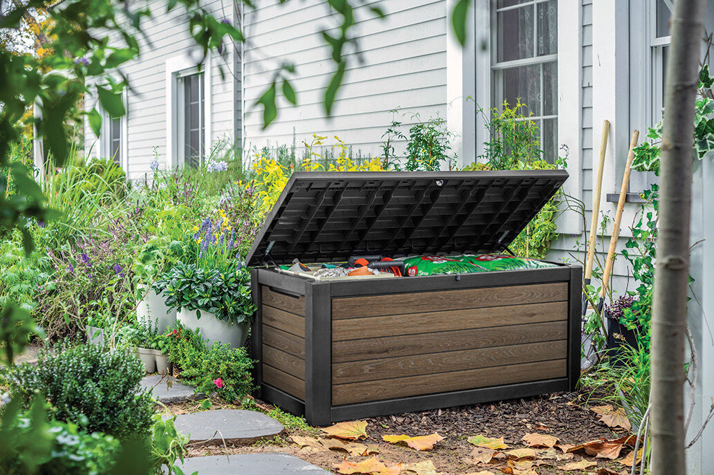 Skrzynia ogrodowa KETER Deco deck box 630 L Jasny-orzech, kłódka, bezpieczeństwo, udźwig, szczelność, Otwarta skrzynia ogrodowa z narzędziami i workami ziemi przy domu.