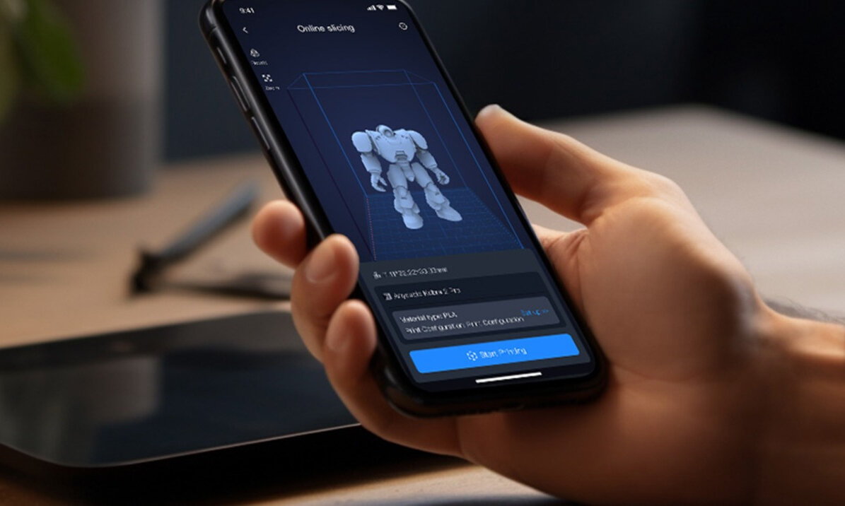 Ręka trzymająca smartfon z aplikacją Anycubic Kobra 2 Pro i modelem robota na ekranie