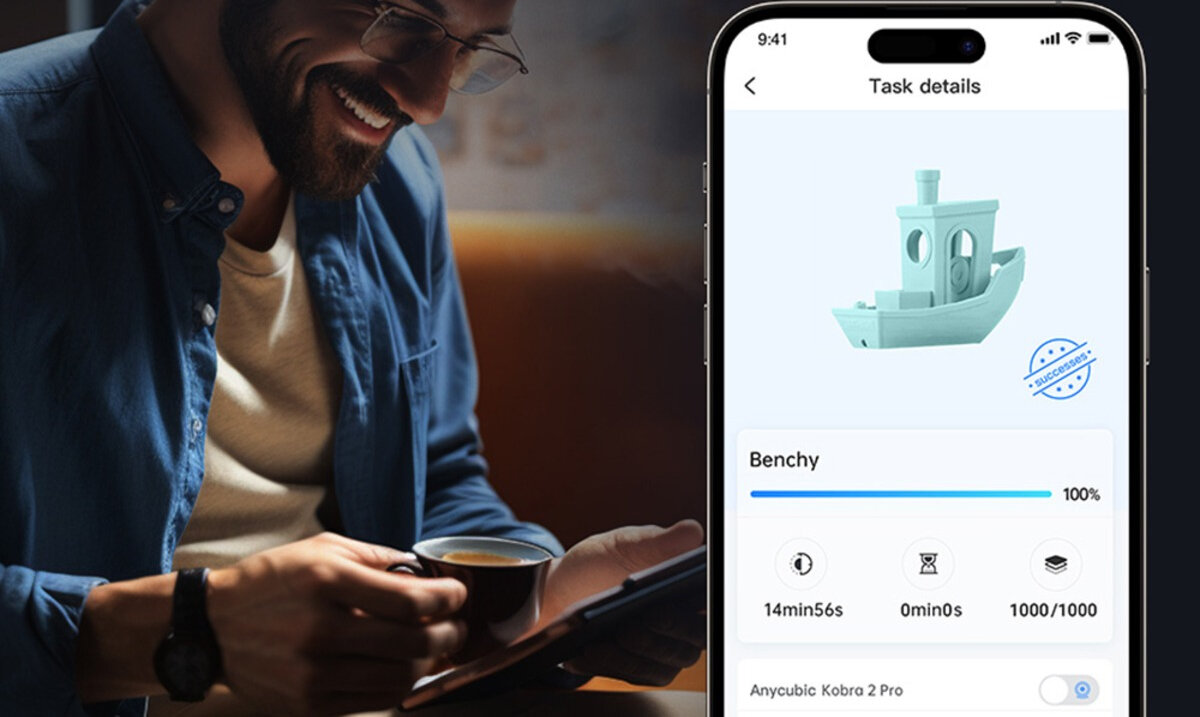 Mężczyzna w okularach trzymający filiżankę, obok smartfon z aplikacją Anycubic Kobra 2 Pro i modelem łódki