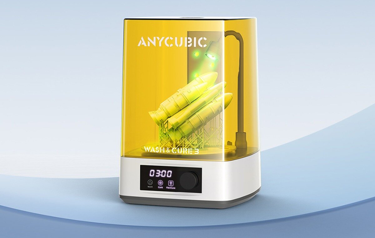 Urządzenie do mycia i suszenia wydruków 3D z przezroczystą, żółtą osłoną, na której widnieje napis \'ANYCUBIC\'. Na panelu sterującym wyświetla się czas \'03:00\' oraz ikony funkcji.