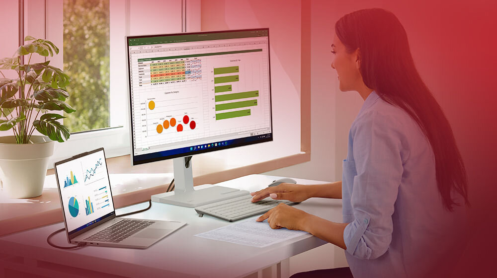 Monitor LENOVO L24m-4A 23.8 cali 1920x1080px IPS 100Hz 1 ms [MPRT] prezentacja monitora w pokoju na biurku kobieta siedząca przy nim i pracująca praca rozrywka przekątna 23,8 cala wyraźny i szczegółowy obraz cienkie ramki