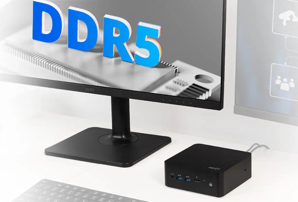 Komputer MSI Cubi NUC 13MQ-062EU Komputer mini PC ustawiony obok monitora z wyświetlonym napisem 'DDR5' oraz klawiatury na białym biurku, pamięć RAM dysk pojemność rozbudowa