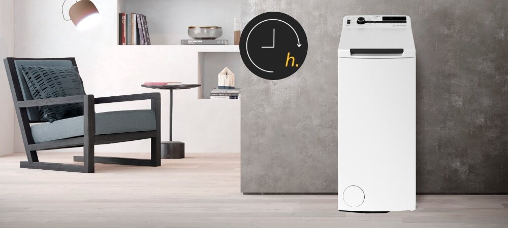 PRALKA WHIRLPOOL MTDLR 65261BS PL/N Na zdjęciu widoczna jest pralka ustawiona w eleganckim wnętrzu z ikoną oznaczającą opóźnienie startu programu. Kompozycja podkreśla możliwość dopasowania czasu prania do codziennych zajęć opóźnienie startu planowanie czas godzina