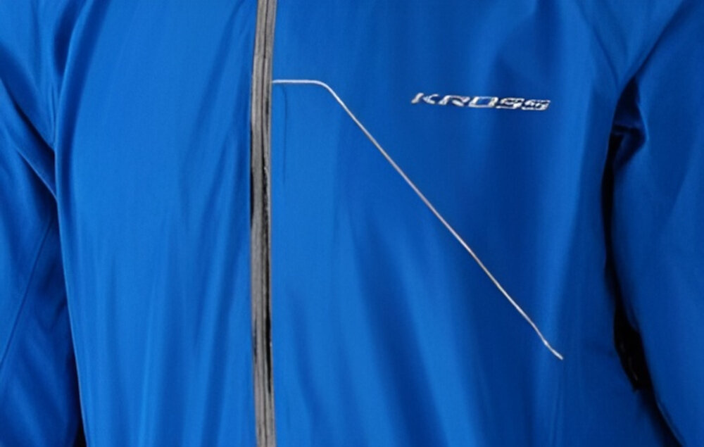 Kurtka rowerowa KROSS Hardshell Rainy (rozmiar S) Niebieski zbliżenie na przód kurtki widoczny napis KROSS wszyte elementy odblaskowe zwiększają widoczność rowerzysty w warunkach ograniczonego światła bezpieczeństwo elementy odblaskowe działają pasywnie nie wymagają dodatkowej energii widoczność z różnych kierunków