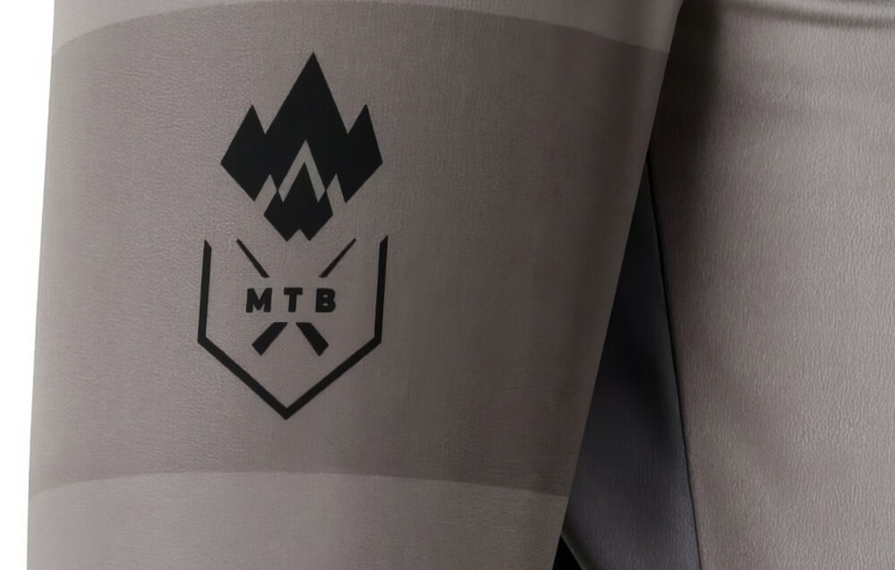 Kurtka rowerowa KROSS Foret (rozmiar XL) Szary przód kurtki zbliżenie na emblemat na rękawie elementy odblaskowe widoczność rowerzysty w słabym oświetleniu lub po zmroku bezpieczeństwo spokojniejsza i bardziej komfortowa jazda