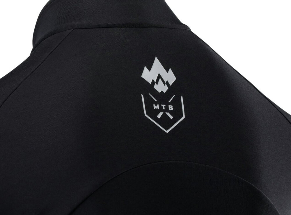 Kurtka rowerowa KROSS Grundo (rozmiar XL) Czarny tył kurtki zbliżenie na emblemat elementy odblaskowe widoczność rowerzysty w słabym oświetleniu lub po zmroku bezpieczeństwo spokojniejsza i bardziej komfortowa jazda