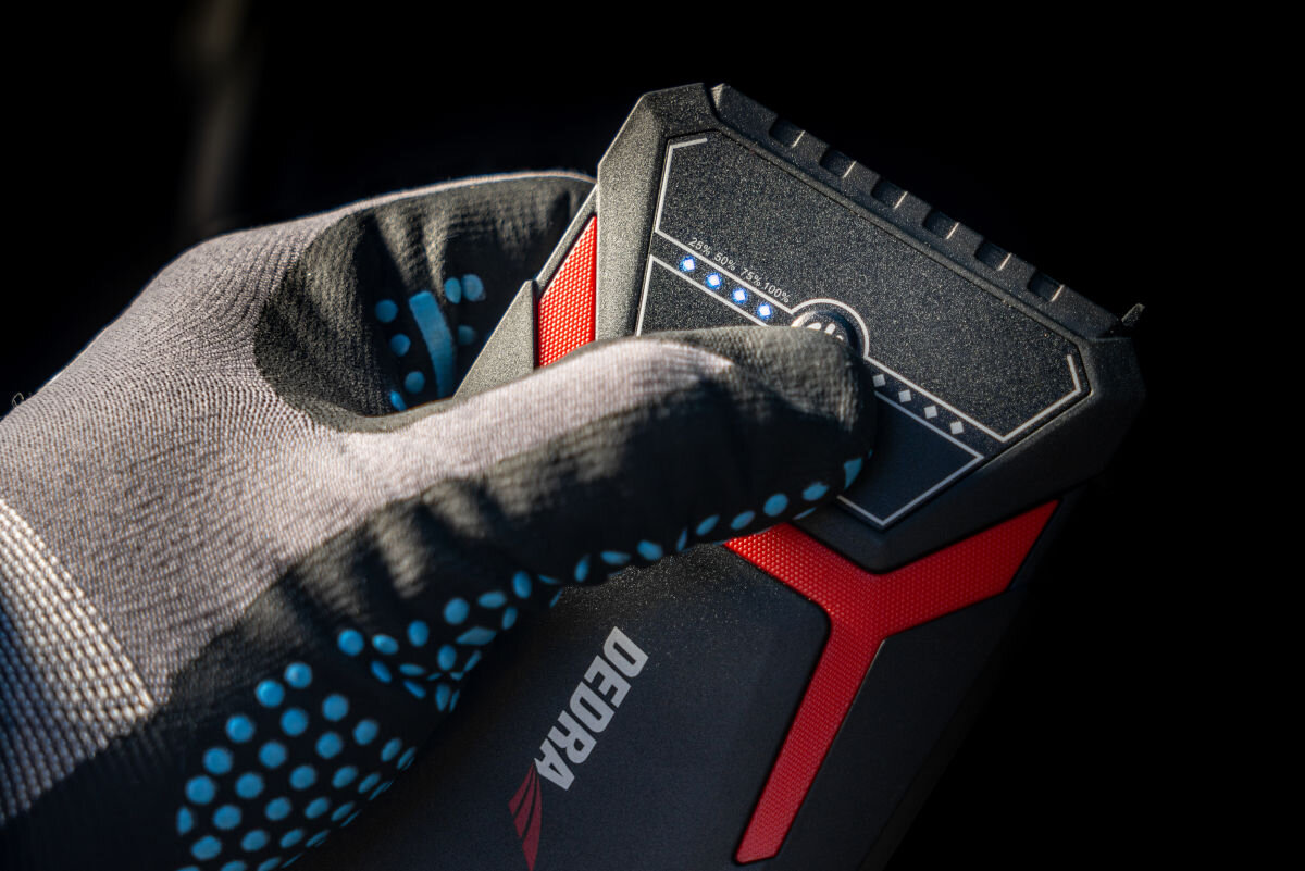 Powerbank DEDRA DEPP0800 Jump Starter 8000 mAh Czarny, latarka, LED, SOS, uniwersalność, Ręka w rękawicy sprawdza poziom naładowania DEDRA