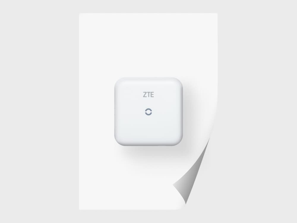 Router ZTE MF17B Małe, białe urządzenie ZTE na tle kartki A4, podkreślające kompaktowe wymiary obudowy. Symbolizuje wygodne umiejscowienie nawet w ograniczonej przestrzeni domowej lub biurowej.