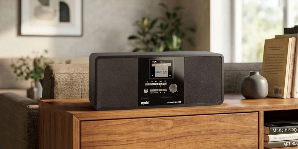 Czarny radioodtwarzacz IMPERIAL Dabman i200 CD Bluetooth stoi na drewnianej komodzie w salonie. Na wyświetlaczu widoczny jest tekst \'STAN FM\'.