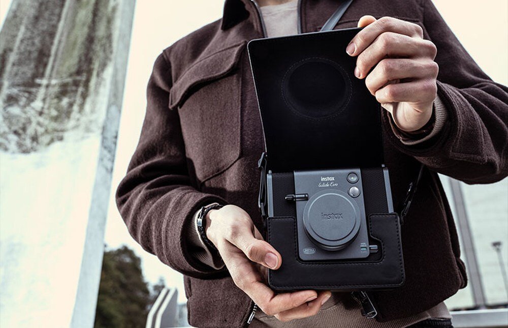Aparat FUJIFILM Instax Wide Evo trzymany przez modela