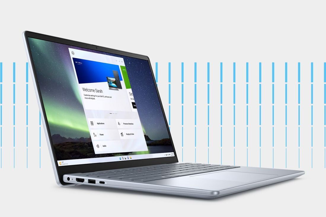 Laptop Dell Inspiron 5440 z widocznym ekranem prezentującym aplikację MyDell, srebrna klawiatura, cienkie ramki ekranu, tło z jasnymi, pionowymi liniami.- aplikacja MyDell 