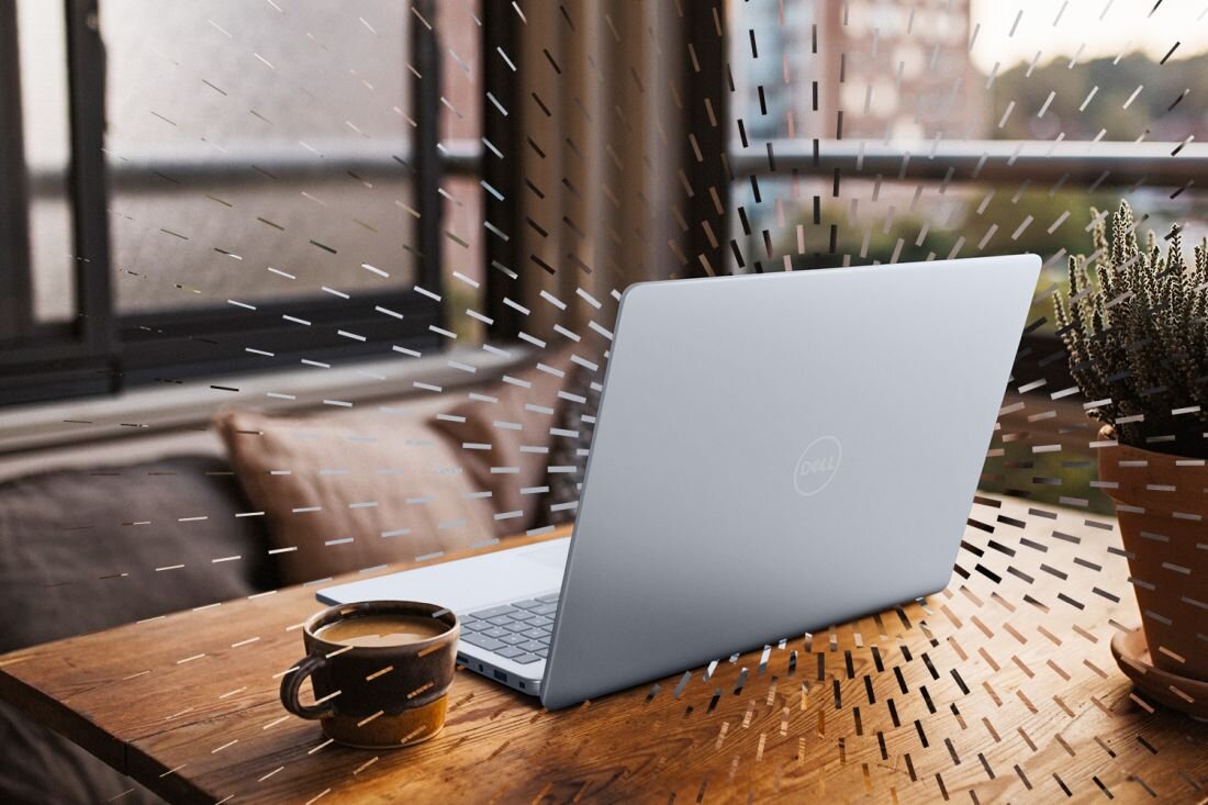 Laptop Dell Inspiron 5640 na drewnianym stole przy oknie, filiżanka kawy i doniczka z rośliną obok, srebrna obudowa, praca w domowym otoczeniu. - Intel Core, dysk SSD PCIe NVMem, RAM DDR5