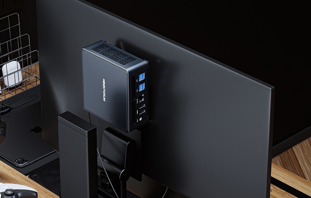 Komputer MINISFORUM Venus UM790 Pro Tył monitora z zamontowaną stacją MINISFORUM, widoczne porty USB, Ethernet i HDMI.