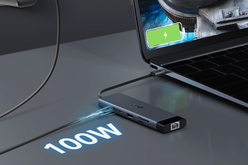 Hub TP-LINK UH9120C Adapter podłączony do laptopa z widocznym kablem zasilającym wpiętym w port USB-C, obok którego widnieje napis '100W' i ikona ładowania na ekranie