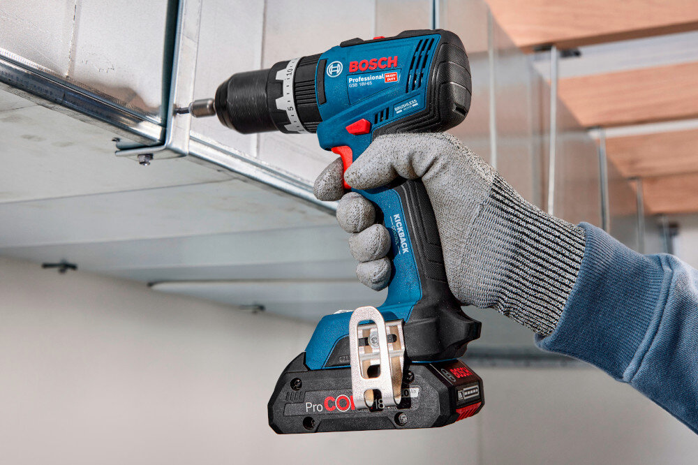 Wiertarko-wkrętarka BOSCH Professional GSB 18V-65 06019N3300 pomieszczenie metalowa konstrukcja osoba trzyma wiertarko-wkrętarkę w dłoniach przykręca śrubę do konstrukcji do wiercenia do wkręcania wszechstronne zastosowanie zasilanie akumulatorowe