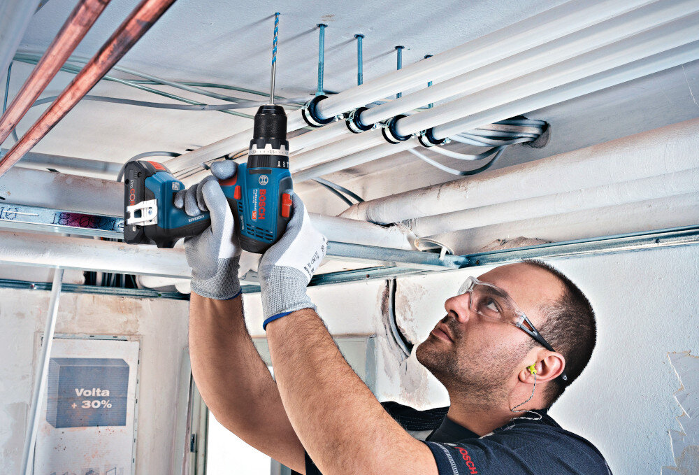 Wiertarko-wkrętarka BOSCH Professional GSB 18V-65 06019N3100 pomieszczenie metalowa konstrukcja osoba trzyma wiertarko-wkrętarkę w dłoniach przykręca śrubę do konstrukcji moment obrotowy 31/65/76 Nm dopasowanie siły pracy do różnych zadań dwubiegowa przekładnia z prędkością 0–550 oraz 0–2.100 obr./min zwiększa się zakres zastosowań i łatwiej dobrać parametry do konkretnego materiału