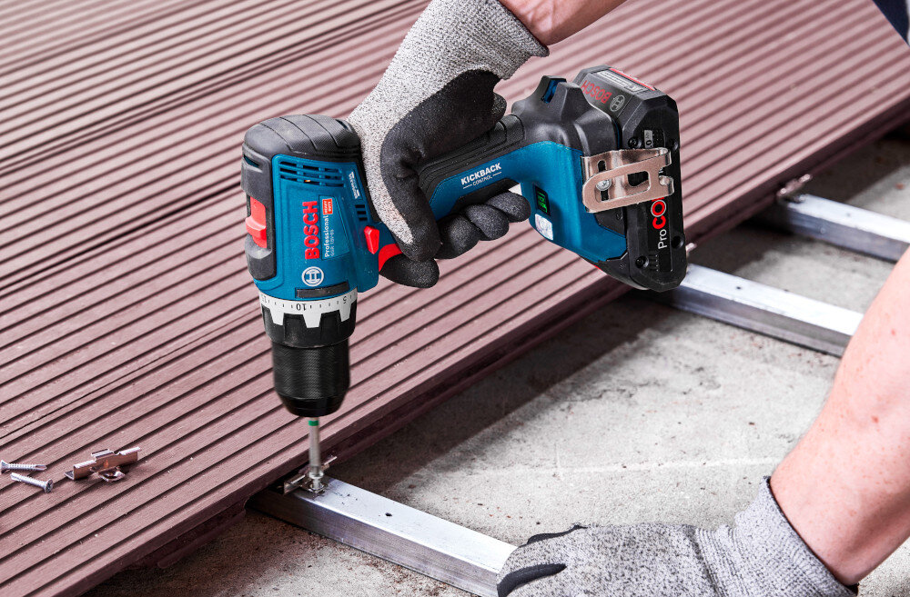 Wiertarko-wkrętarka BOSCH Professional GSR 18V-65 06019N3200 podest osoba trzyma wiertarko-wkrętarkę w dłoniach przykręca śrubę do konstrukcji funkcja KickBack Control wykrywa nagłe zablokowanie wiertła lub bitu i automatycznie zatrzymuje silnik zmniejsza ryzyko utraty kontroli redukuje obciążenie nadgarstka sprzyja stabilniejszemu prowadzeniu urządzenia zwiększa bezpieczeństwo