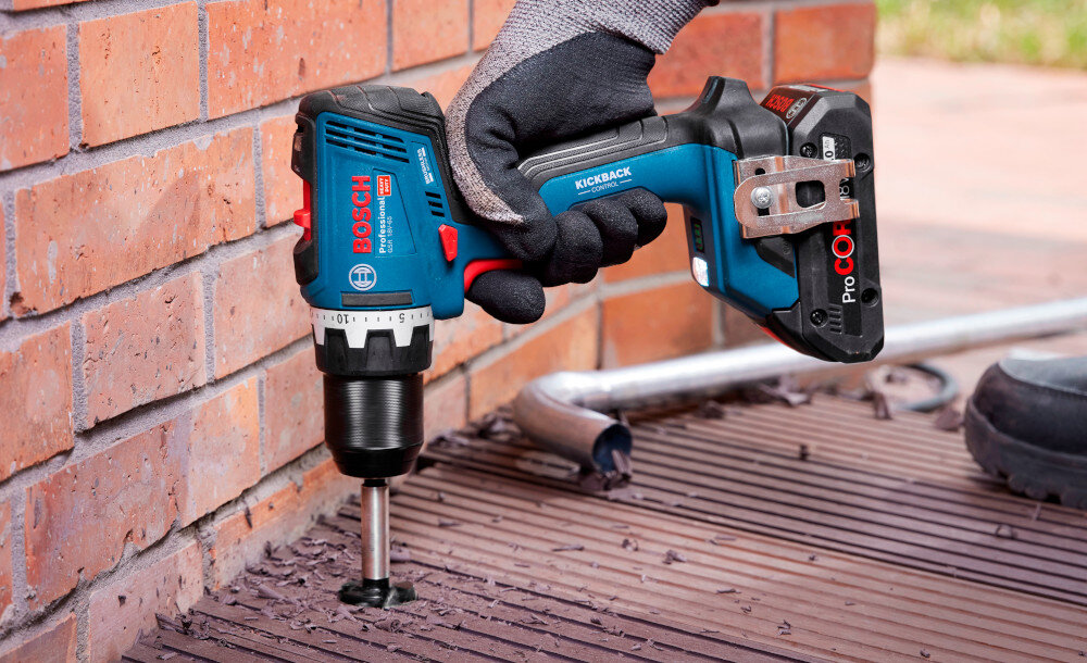 Wiertarko-wkrętarka BOSCH Professional GSR 18V-65 06019N3203 ściana z cegły drewniany podest osoba wierci otwór w podeście do wiercenia do wkręcania wszechstronne zastosowanie zasilanie akumulatorowe