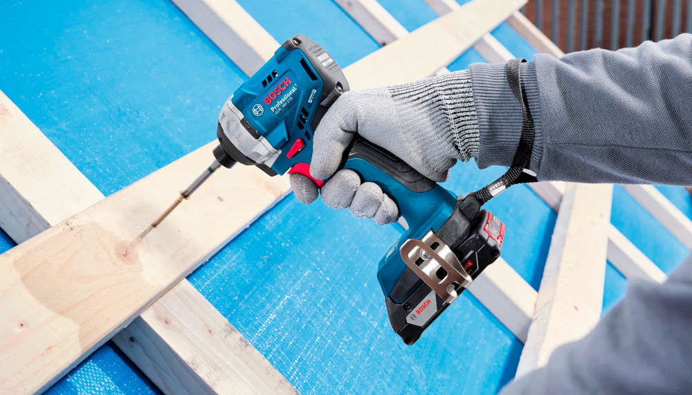 Klucz udarowy BOSCH Professional GDR 18V-215 06019N2002 plac budowy dach osoba wkręca śrubę w drewnianą ramę okienną regulacja prędkości obrotowej na spuście w trybie pierwszym w zakresie 0-2100 obr./min w trybie drugim w zakresie 0-3300 obr./min obroty prawo/lewo obroty w prawo umożliwiają wkręcenie śruby lub dokręcenie nakrętki obroty w lewo odpowiadają za odkręcenie nakrętki lub wykręcenie śruby