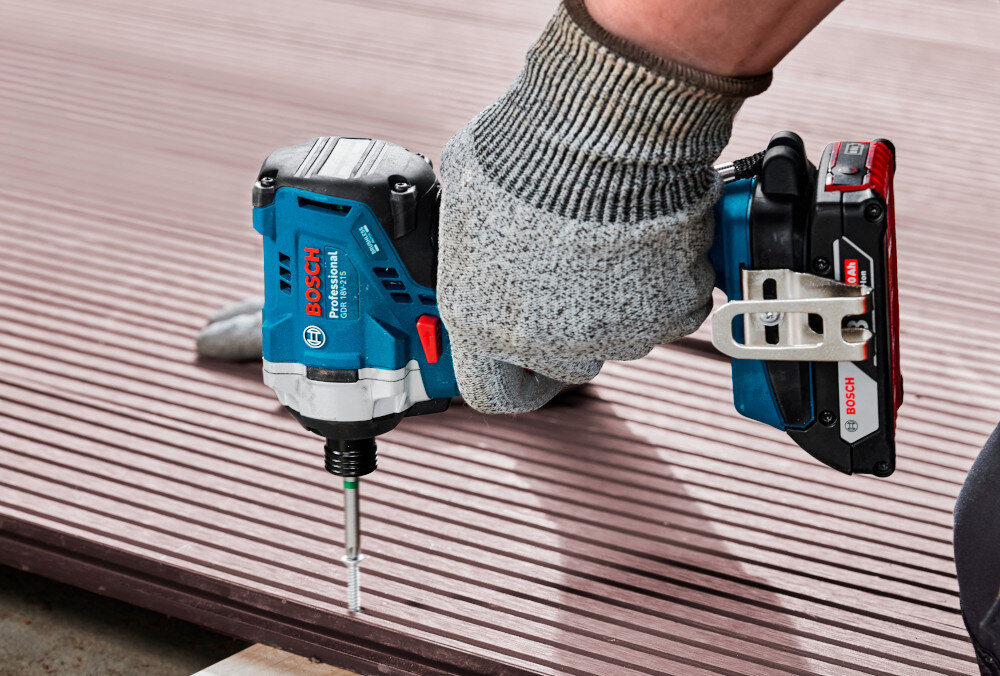 Klucz udarowy BOSCH Professional GDR 18V-215 06019N2022 plac budowy drewniana podłoga osoba dokręca deskę do podłogi maksymalny moment obrotowy 215 Nm sprawne wykonywanie prac montażowych w elementach drewnianych wkręcać śruby o długości 50 mm długie śruby 80–140 mm w drewnianych ramach i konstrukcjach nośnych