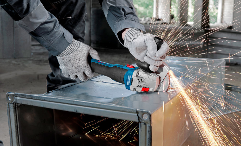 Szlifierka kątowa BOSCH Professional GWS 18V-8 06019N9020 osoba trzyma szlifierkę w dłoniach tnie metalowy element profesjonalna renomowana firma BOSCH solidne narzędzie do obróbki materiałów wysoka moc wydajność do cięcia szlifowania polerowania