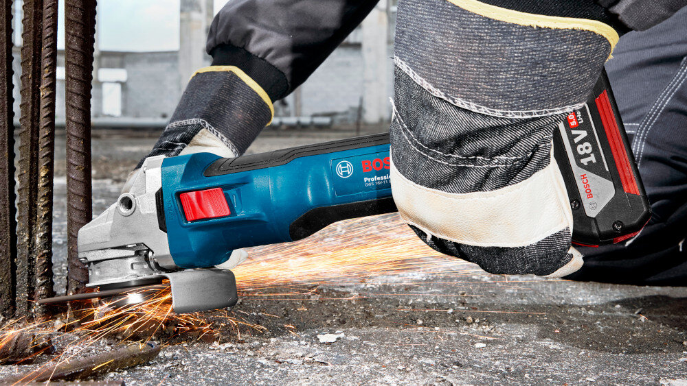 Szlifierka kątowa BOSCH Professional GWS 18V-11 S 06019N4001 osoba trzyma szlifierkę w dłoniach tnie metalową rurę wszechstronne narzędzie dla majsterkowiczów bezpieczne użytkowanie kontrola potężne obroty