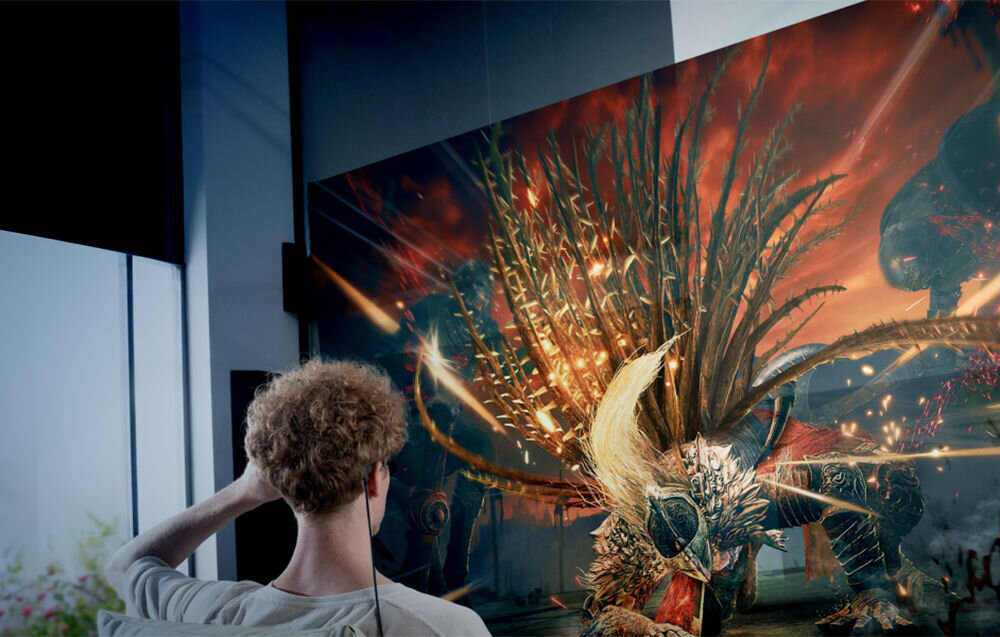 Okulary VITURE Pro XR Czarny prezentacja okularów podczas użytkowania mężczyzna w pokoju z wirtualnym ekranem przed nim UltraClarity™ dbanie o czystość i ostrość obrazu eliminacja efektu rozmycia powłoki antyodblaskowe anty-widmo redukcja zmęczenia oczu bez efektu migotania