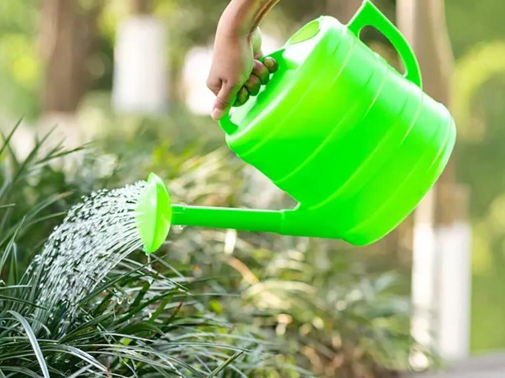Konewka BLACK FOREST 1600 Zielony 10L, nawadnianie, ogród, woda, rabaty, Dziecko podlewa zieloną konewką rośliny.
