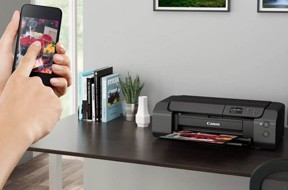 Drukarka CANON Pixma Pro-200S Druk w kolorze, Wi-Fi urządzenie na biurku w pomieszczeniu ręka trzymająca telefon łączność Wi-Fi Ethernet stabilna komunikacja