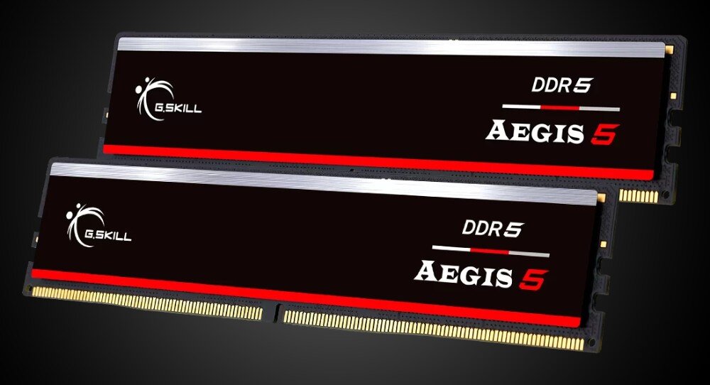 Na obrazie widoczne są dwa moduły pamięci RAM z oznaczeniami \'G.SKILL\', \'DDR5\' oraz \'Aegis 5\'. Moduły mają czarno-czerwony design z metalicznymi elementami.