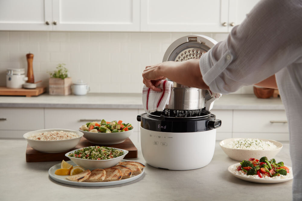 Ryżowar INSTANT POT Multigrain ryżowar stoi an blacie osoba wyciąga stalowy koszyk z urządzenia jasne tło posiłki wokół urządzenia wygodne korzystanie wewnętrzny garnek z nieprzywierającą powłoką stalowy koszyk CarbReduce zdejmowana pokrywa możliwość mycia w zmywarce ułatwia sprzątanie po gotowaniu zabezpieczenie termiczne ochrona przed przegrzaniem bezpieczne użytkowanie solidny funkcjonalny