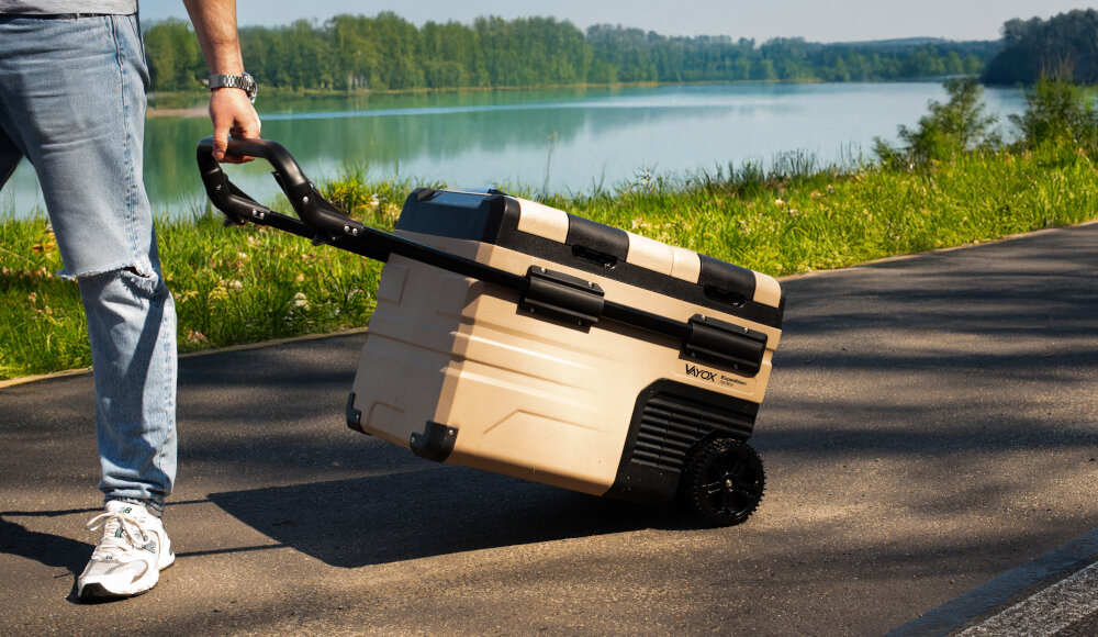LODÓWKA TURYSTYCZNA VAYOX VA-EW39 wizualizacja mężczyzna trzymający uchwyt chodnik natura tło zieleń obsługa panel dotykowy LCD aplikacja mobilna Bluetooth