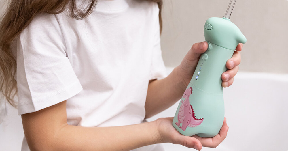 Irygator SEYSSO Kids Dinosaur Różowo-zielony Przyjazny dla dzieci Lekka konstrukcja antypoślizgowa powierzchnia dziecko trzyma w dłoniach irygator