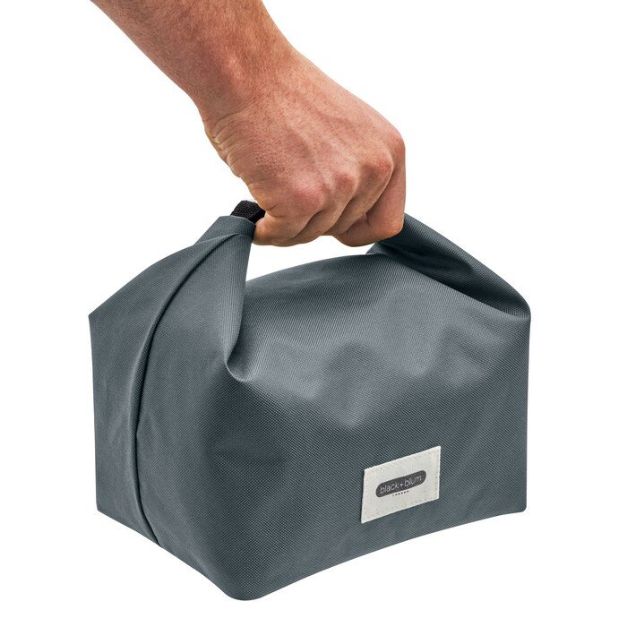 Szara torba termiczna trzymana za uchwyt, z widocznym logo \'black+blum\' na przodzie.