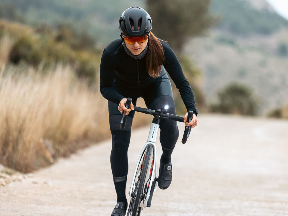 Kask rowerowy LAZER Vento KinetiCore Kobieta jadąca na rowerze szosowym w kasku Lazer Vento, prezentująca stabilność kasku podczas jazdy.