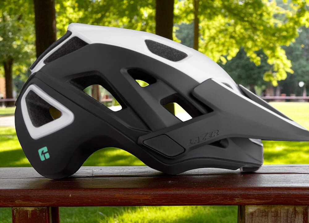Kask rowerowy LAZER Jackal KinetiCore Czarno-biały MTB (rozmiar M) osoba w założonym kasku na rowerze w górach