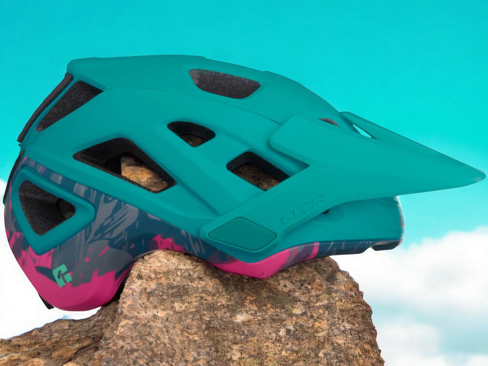 Kask rowerowy LAZER Jackal KinetiCore Turkusowy MTB (rozmiar L) osoba w założonym kasku na rowerze w górach