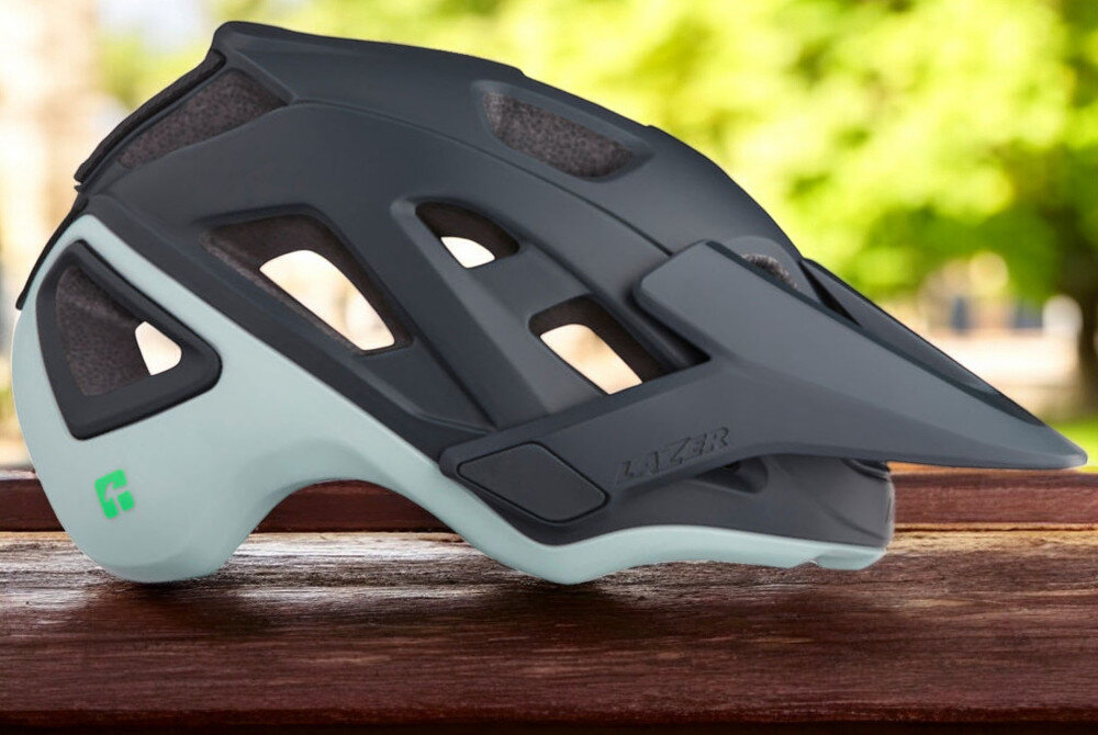Kask rowerowy LAZER Jackal KinetiCore Jasnoniebieski MTB (rozmiar M) osoba w założonym kasku na rowerze w górach