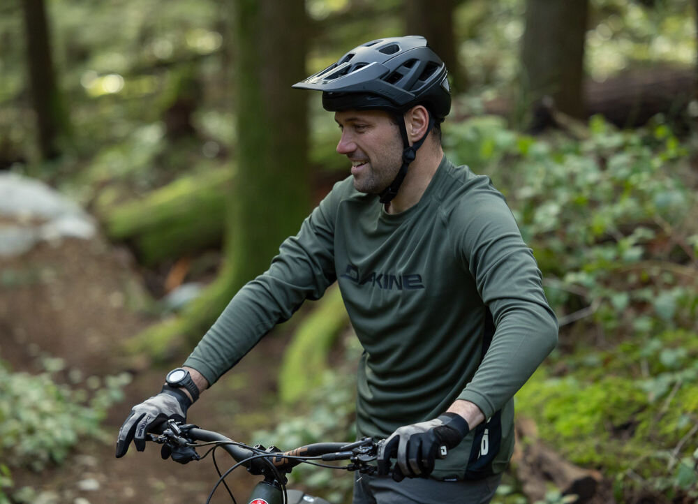 Kask rowerowy LAZER Jackal KinetiCore Czarny MTB (rozmiar M) osoba w założonym kasku na rowerze w górach