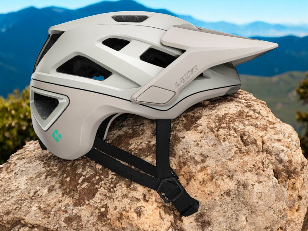 Kask rowerowy LAZER Jackal KinetiCore Piaskowy MTB (rozmiar M) osoba w założonym kasku na rowerze w górach