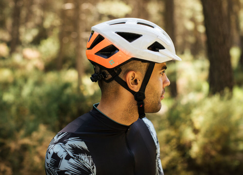 Kask rowerowy LAZER Cerro KinetiCore Biało-pomarańczowy MTB (rozmiar M) osoba w kasku regulująca obwód kasku
