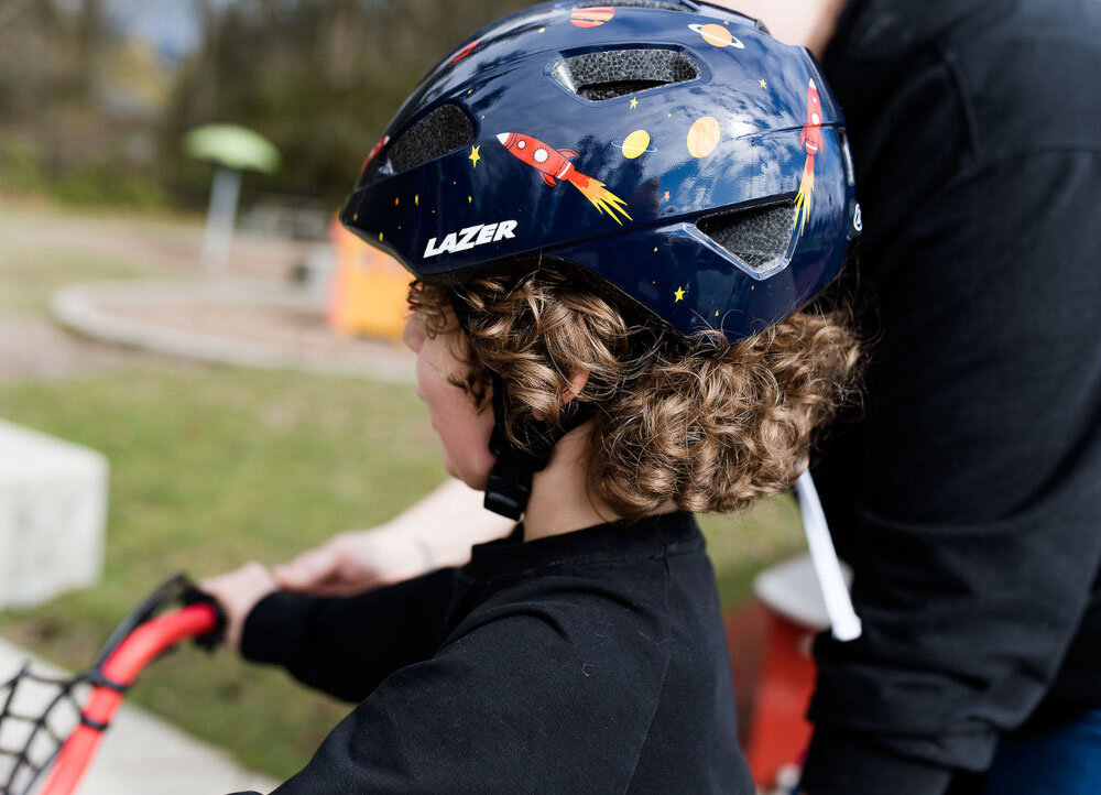 Kask rowerowy LAZER Nutz KinetiCore 2.0 Granatowy dla Dzieci (rozmiar 50-56) plac zabaw dziecko w kasku widoczne od tyłu wnętrze kasku wyposażono w miękką wyściółkę materiał EPS skutecznie pochłania energię waga około 240 g homologacje CE EN 1078 i CPSC spełnienie norm bezpieczeństwa kask został przetestowany pod kątem realnych zagrożeń zapewnia ochronę na poziomie wymaganym podczas jazdy po drogach publicznych
