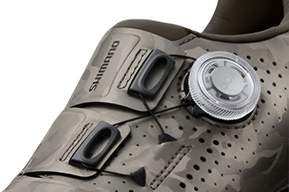 Buty rowerowe SHIMANO SH-RX600 Szary rozmiar 41 zbliżenie na pokrętło białe tło system BOA® z pokrętłem L6 dodatkowy pasek szybkie i precyzyjne dopasowanie butów do stopy łatwe regulowanie zacisku eliminuje ucisk i poprawia krążenie