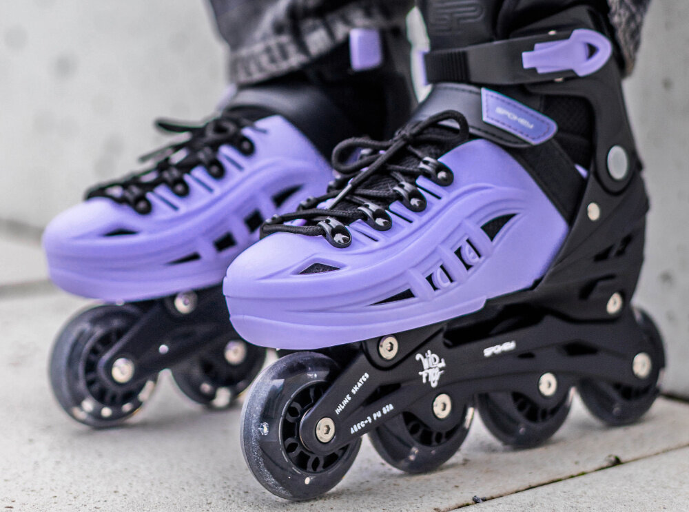 Łyżworolki SPOKEY 4ONE 4w1 (rozmiar 34-38) Czarny-fioletowe chodnik osoba w łyżworolkach zbliżenie na stopy całoroczna aktywność do jazdy latem i zimą aktywne spędzanie czasu hobby pasja